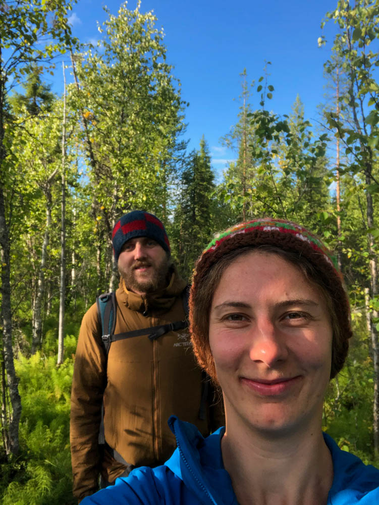 Wanderung am Arctic Circle in Finnlands Norden. Melanie und Julian stehen in einem Wald.