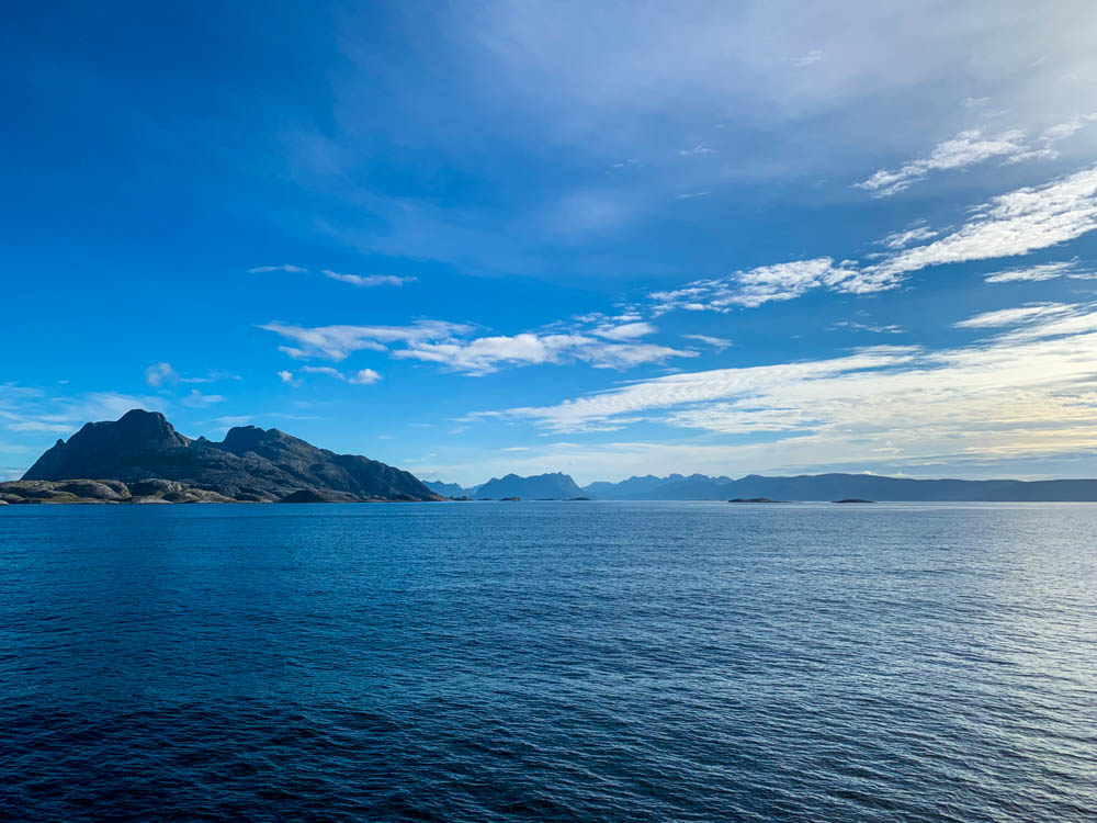 Ausblick auf Atlantik bei Fährüberfahrt Moskenes nach Bodø. Nur wenige Wolken am Himmel, ansonsten blau.