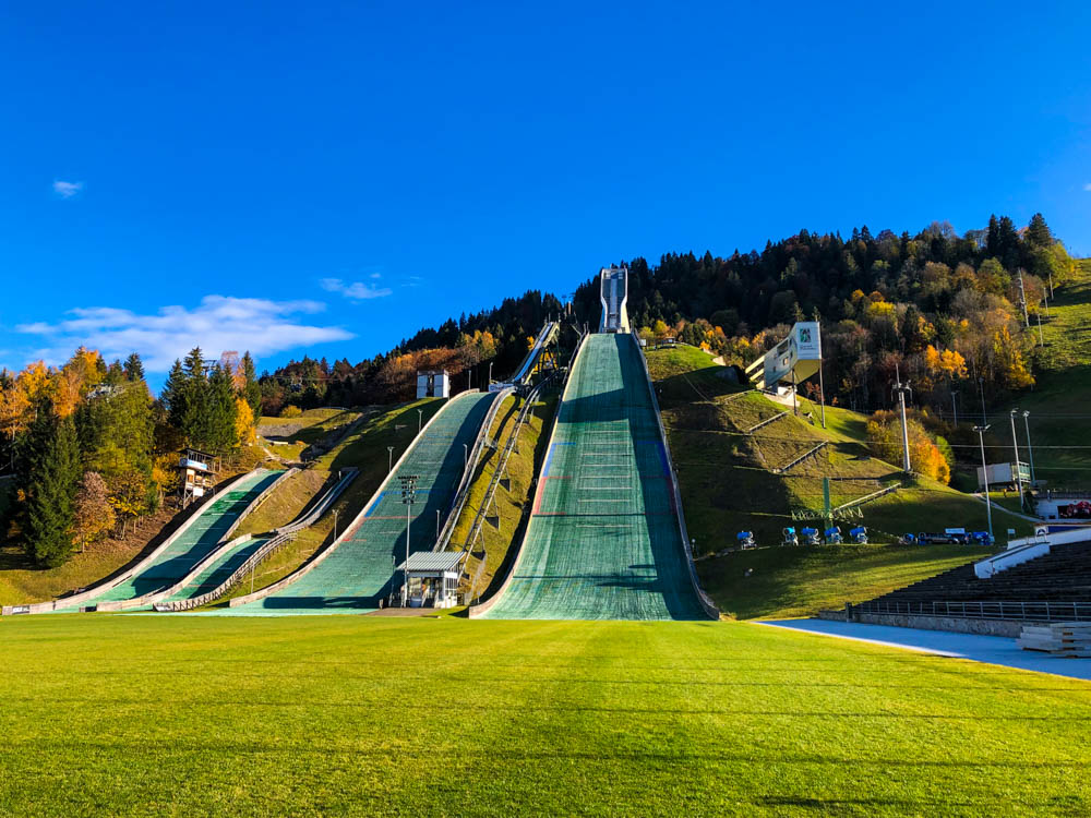 Deutsche Alpen - Skisprungschanzen im Olympiastadion Garmisch-Partenkirchen. Das Bild wurde auf der Landezone aufgenommen und die vier Schanzen sind frontal im Bild.