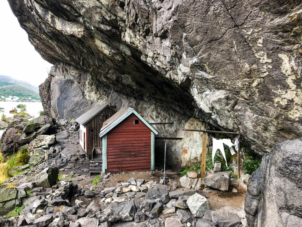 Die Helleren Häuser sind von der Seite zu sehen. Der Felsvorsprung ragt über die Häuser hinaus. Tour bis nach Kristiansand