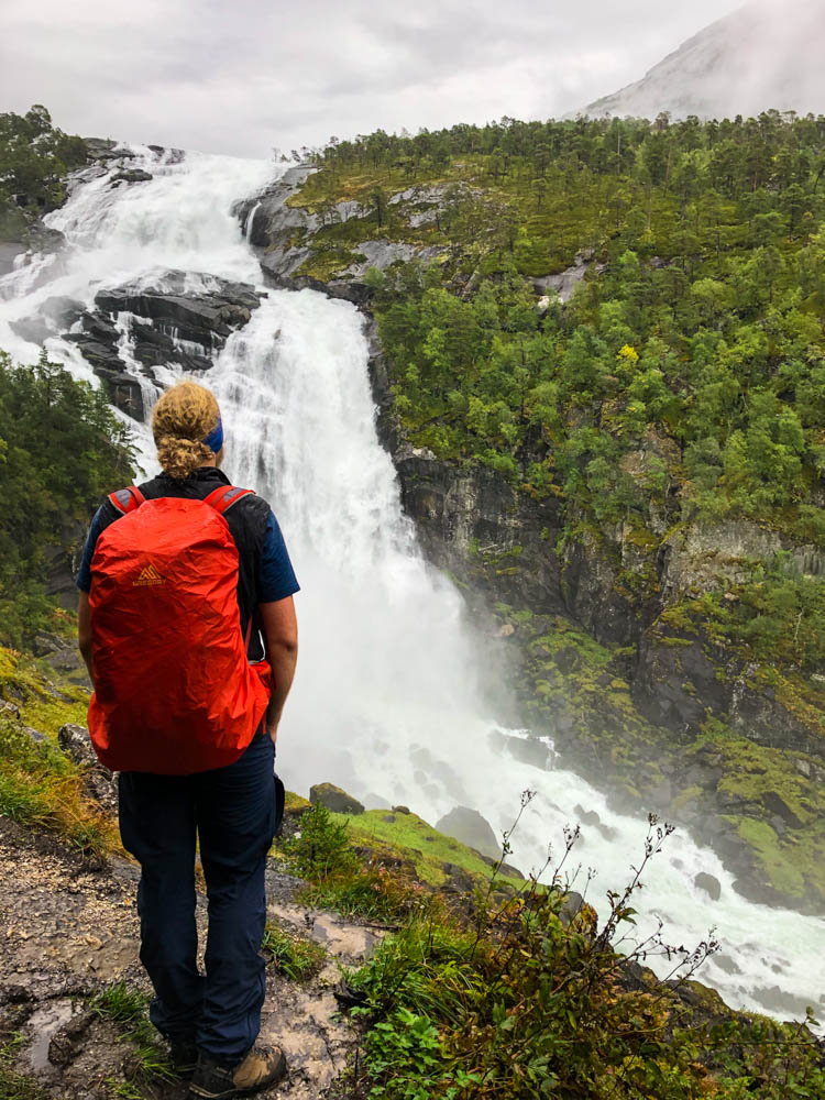 Julian schaut auf einen riesigen Wasserfall bei unserer Wanderung in Kinsarvik. Norwegen Bergpässe, Fjorde und Wasserfälle