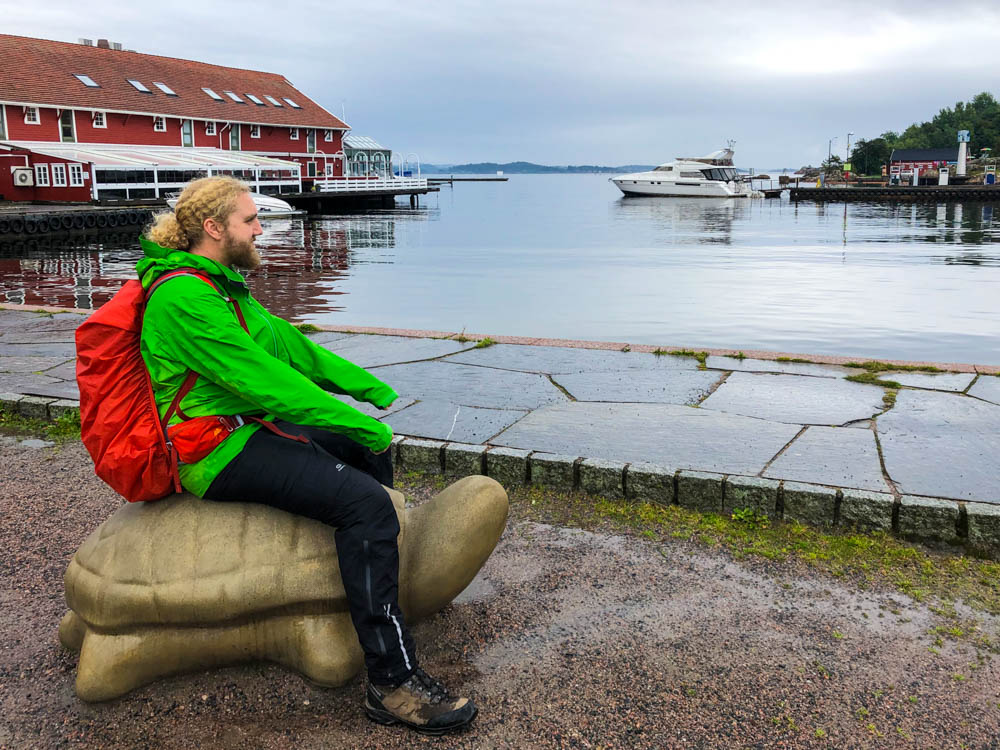 Julian reitet auf einer Statue in Form einer Schildkröte. Diese steht am Yachthafen in Kristiansand. Tour bis nach Kristiansand