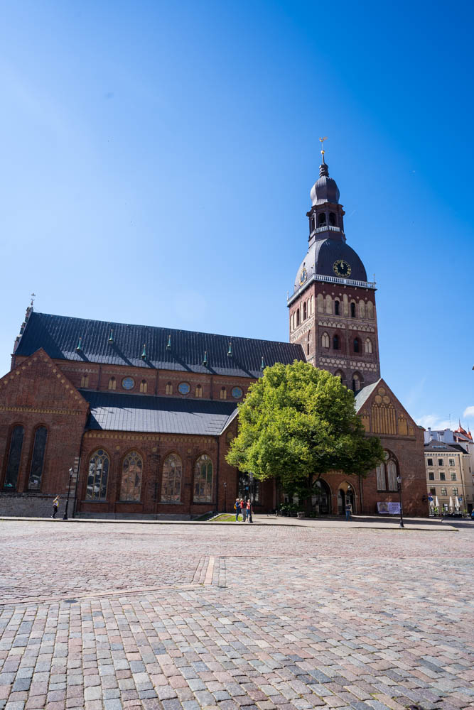 Blick auf den Dom in Riga, Lettland. Der Himmel ist strahlend blau und es sind kaum Menschen unterwegs.
