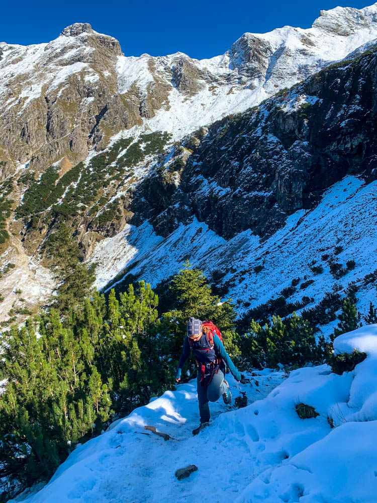 Melanie läuft über ein Schnee und Eisfeld auf dem schmalen Aufstiegspfad zum Rubihorn. Tour durch die deutschen Alpen