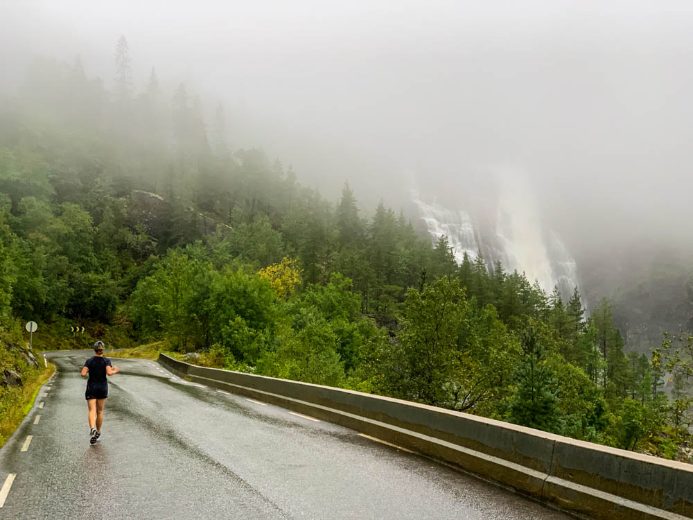 Melanie joggt die Straße am Skjervsfossen nach unten. Norwegen Bergpässe, Fjorde und Wasserfälle