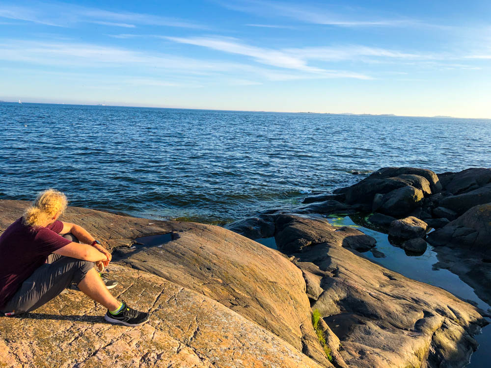 Julian sitz auf einem Fjell auf Suomenlinna und schaut auf die weite Ostsee. Skandinavien wir kommen