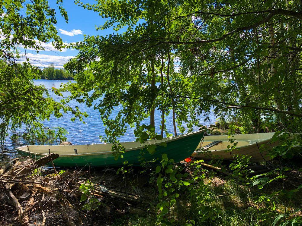 Zwei Boote liegen am einem wild bewachsenen Ufer in Tampere.