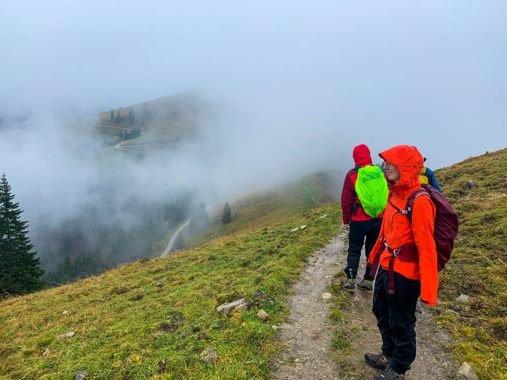 Deutsche Alpen - Eingepackt in Regenkleidung geht die kleine Wandergruppe (Melanie, Tatjana, Timo, Julian) in eine dichte Wolkenfront hinein.