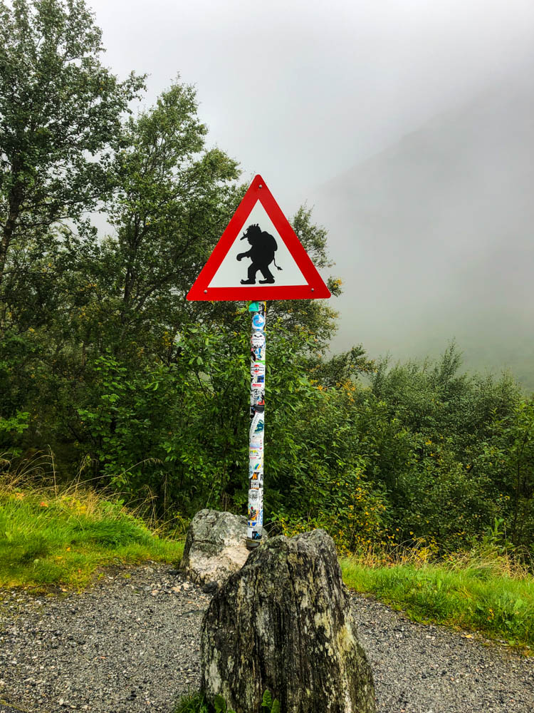 Verkehrsschild (Gefahrenzeichen rot weißes Dreieck) auf welchem vor einem Troll gewarnt wird. Im Hintergrund ist nur eine Nebelwand zu sehen.