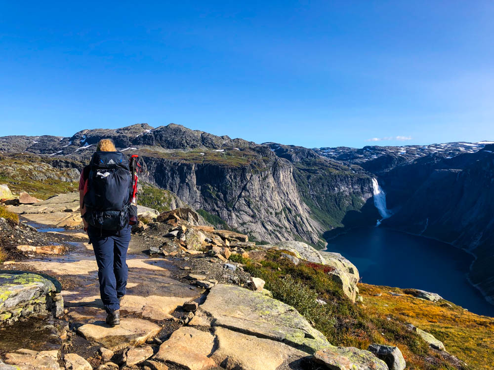 Norwegen, Julian mit großem Rucksack auf dem Weg zu Trolltunga. Blauer Himmel