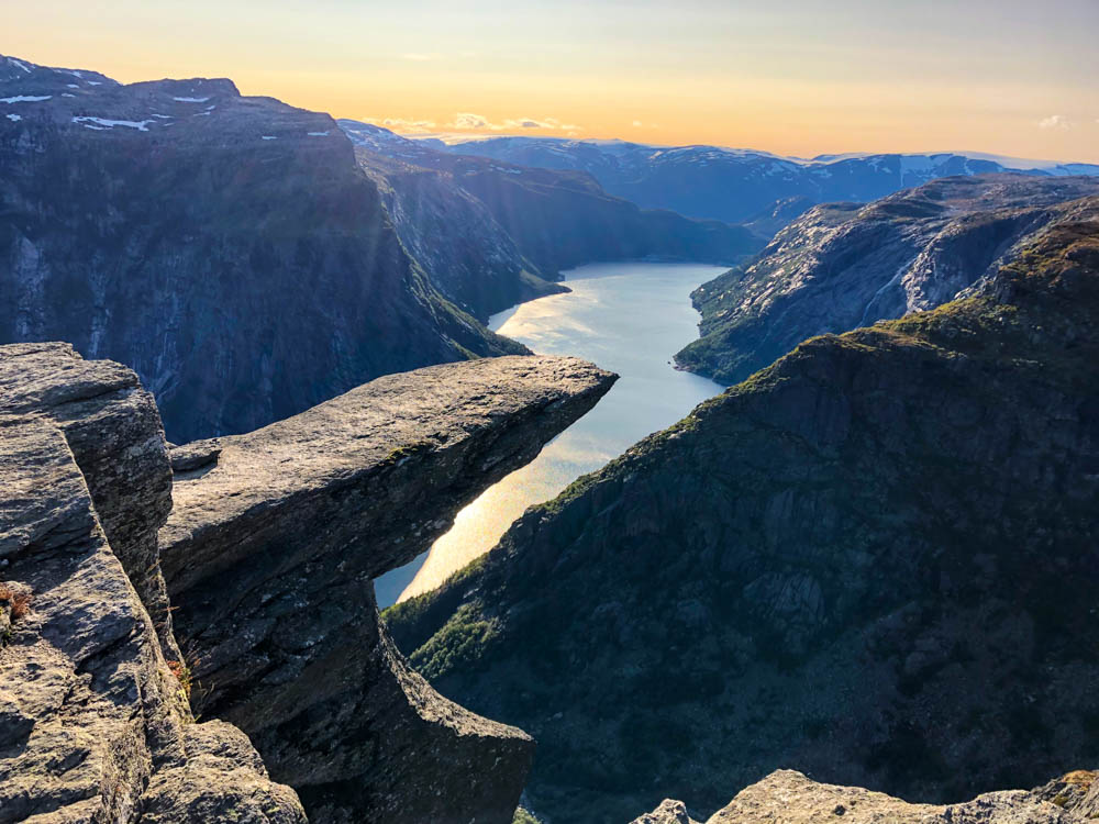 Norwegen, Trolltunga nach Sonnenuntergang mit orangenem Himmel. Berühmte und besondere Felsformationen in Norwegen