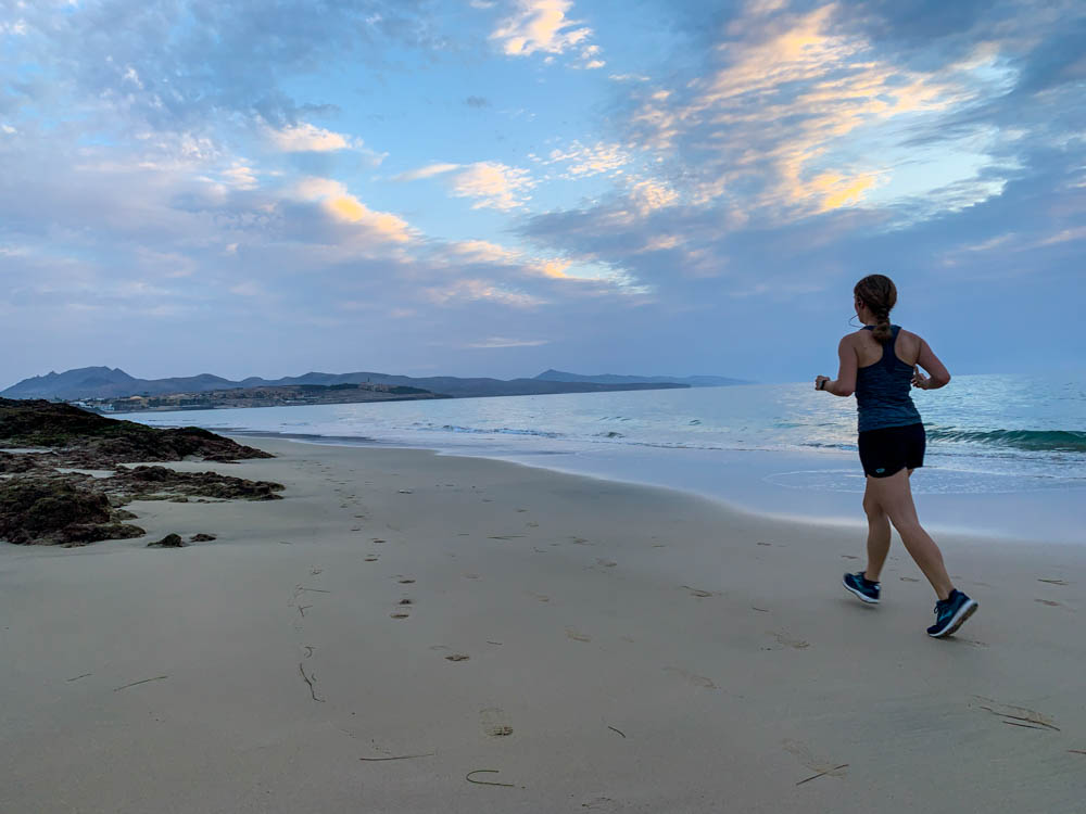 Melanie joggt am Strand von Costa Calma. Der Himmel ist leicht orange. Auch Sport gehört zu einer Auszeit auf Fuerteventura.