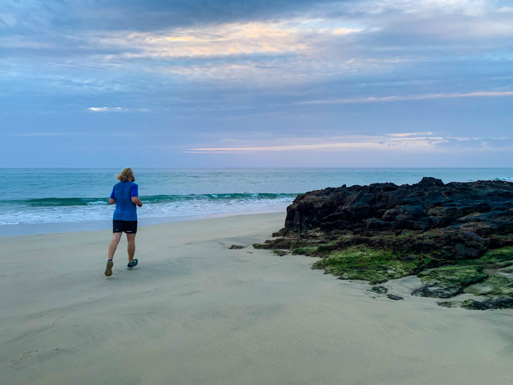 Julian joggt am Strand von Costa Calma. Der Himmel ist leicht orange. Auch Sport gehört zu einer Auszeit auf Fuerteventura.