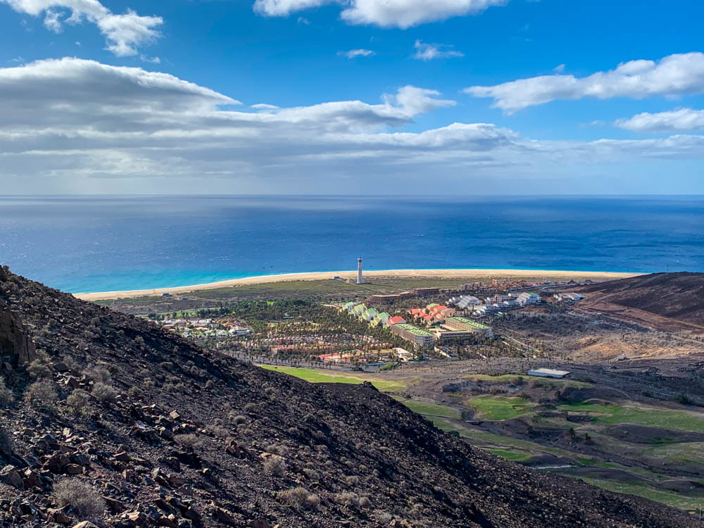 Blick von Hügel auf Morro Jable. Leuchtturm und Strand von Jandia sind zu sehen, dahinter der Atlantik. Wanderung Fuerteventura