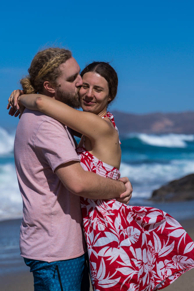 Julian küsst Melanie auf die Wange. Sie ist zur Kamera gedreht, hat die Augen geschlossen und genießt sichtlich lächelnd die Auszeit auf Fuerteventura.