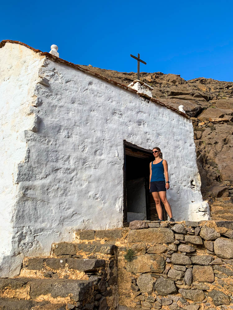 Melanie steht vor der kleinen Wallfahrtskapelle im Barranco de las Peñitas. Länger auf Fuerteventura bleiben lohnt sich. Wanderung