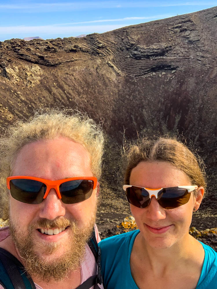Selfie von Melanie und Julian am Calderón Hondo. Beide haben eine Sonnenbrille auf. Im Hintergrund sieht man den tiefen Krater.