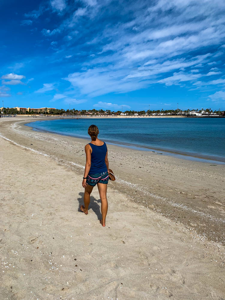 Melanie spaziert am Strand bei Caleta de Fuste. Unsere Zeit auf Fuerteventura geht zu Ende - letzter Tag auf der Insel