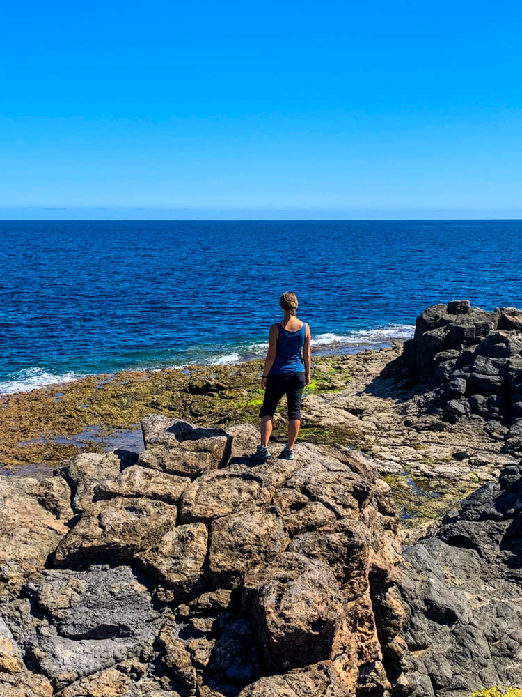 Melanie steht auf einem Felsen und blickt in die Ferne Richtung Atlantik. Unsere Zeit auf Fuerteventura geht zu Ende