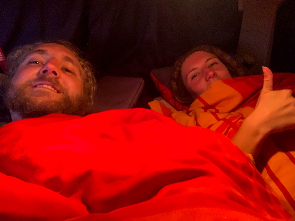 Melanie und Julian liegen im Bett des Mini-Campers Astrarix.