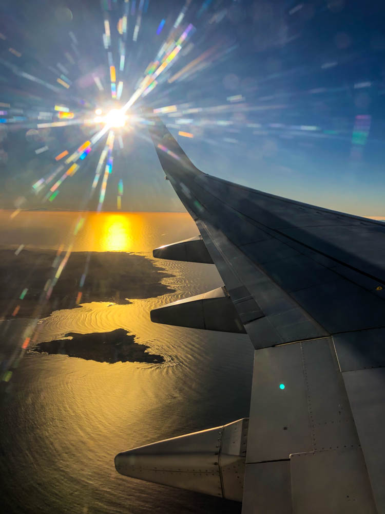 Fotografie aus Flugzeugfenster. Die Sonne geht demnächst unter und es ist der letzte Blick auf Fuerteventura und Lobos.