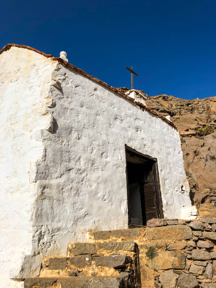 Nahaufnahme der Kapelle im Barranco de las Penitas. Die Kapelle ist weiß und das Kreuz auf der Kapelle ist schön zu sehen.