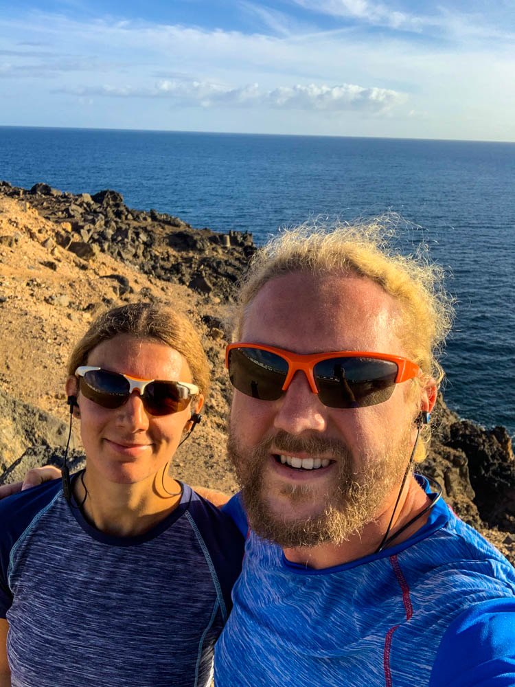 Selfie von Melanie und Julian nach einer Joggingrunde. Im Hintergrund ist der Atlantik sowie der blaue Himmel zu sehen.