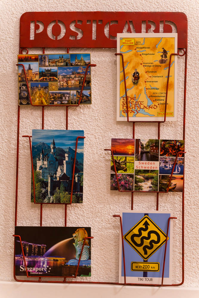 Es sind ein paar verschiedene Postkarten aus verschiedenen Reiseländer in einem Kartenständer hergerichtet. Länderguide