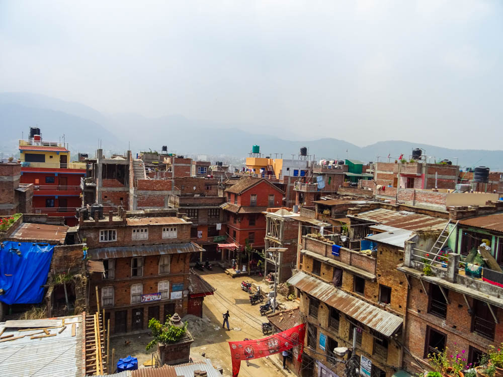 Blick von Dach über Bhaktapur. Es sind viele baufällige Häuser zu sehen, über der Stadt hängt Smog. Eindrücke Fernreise Nepal