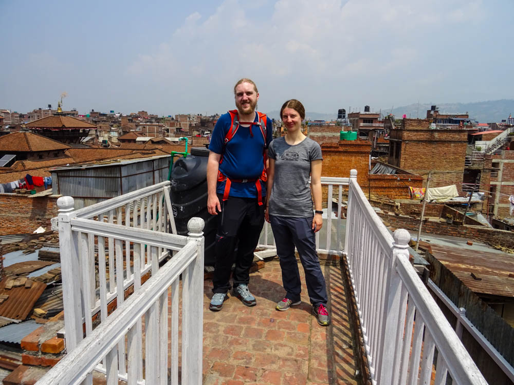 Melanie und Julian stehen auf einer Dachterrasse in Bhaktapur. Im Hintergrund sind viele Häuser zu sehen. Fernreise Nepal Eindrücke