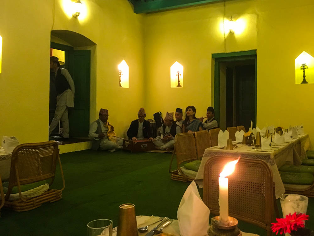 Blick in Gastraum in Restaurant in Kathmandu. Die Tische sind klassisch tiefer gelegt und man sitzt quasi auf dem Boden auf einem Sitzkissen. Ein paar Musiker sitzen bereits auf dem Boden in der Ecke und warten auf ihren Auftritt. Unsere ersten Eindrücke Fernreise Nepal.