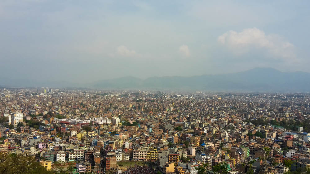 Kathmandu Panorama - in der unteren Hälfte des Bildes sind die Häuser Kathmandus zu sehen, im oberen Teil des Bildes hängt der Smog der Stadt am Himmel.