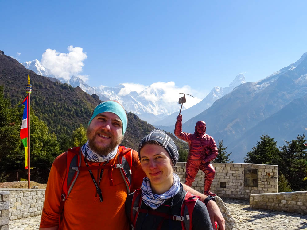 Melanie und Julian stehen im Außenbereich des Sagarmatha Nationalpark Museums und posieren u.a. vor eine Statue von Norgay Tenzing und dem Mount Everest. Trekking Fortsetzung