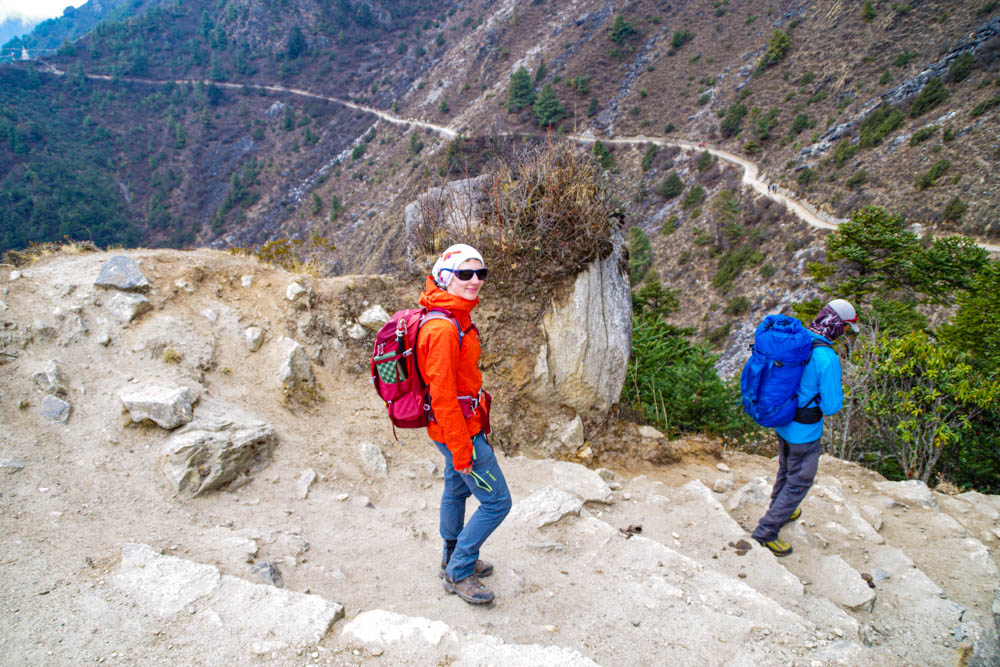 Melanie und Guide Keshar im Abstieg auf dem Mount Everest Base Camp Trek Richtung Namche Bazar. Man sieht das die beiden in eine Kurve laufen. Fortsetzung Trekking