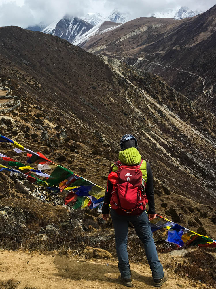 Packliste Trekkingtour Nepal - Melanie mit ihrem Tagesrucksack blickt in ein Tal im Himalaya Gebirge