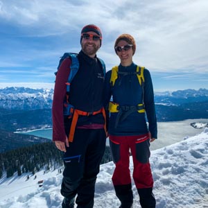 Sonne in den Alpen: Melanie und Julian grinsen bei einer Schnee Bergtour am Jochberg in die Kamera
