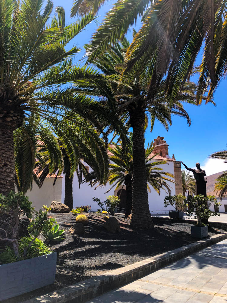 Aufnahme vom Kirchplatz in Betancuria. Ein sehr bekanntes Fotomotiv wenn es ums entdecken von Fuerteventura geht. Es stehen viele Palmen rund um die Kirche und es ist ein schöner gepflegter Ort.