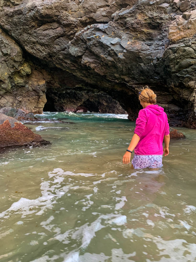 Melanie ist bis zu den Knien im Atlantik versunken und erkundet eine Höhle. Fuerteventura entdecken - Höhlenforscher