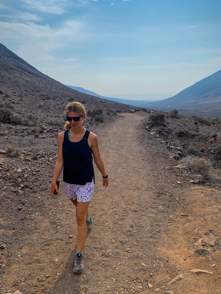 Melanie bei Wanderung nach Cofete. Im Hintergrund ist die Ostküste Fuerteventura zu sehen, der Himmel ist blau.