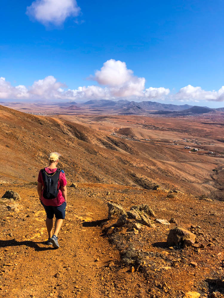 Julian wandert in der kargen Landschaft von Fuerteventura. Er ist dabei neue Ecken rund um Betancuria zu entdecken.