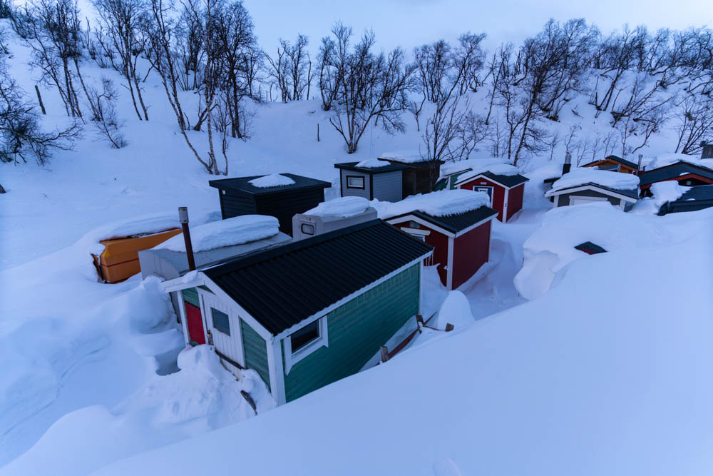 Schneebedeckte Fischerhäuser am See Lappland Schweden