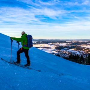 Winter in den Alpen - Splitboardtour Nesselwang. Julian im Aufstieg blickt ins Tal