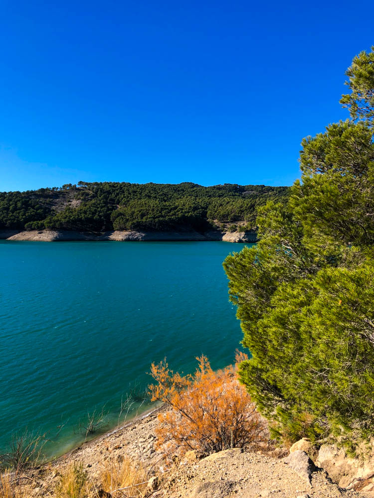 See in Gebiet bei El Chorro. Der Himmel ist kräftig blau, der See türkis und der Wald drum herum bietet einen schönen Kontrast. Rückfahrt über Spanien Landesinnere