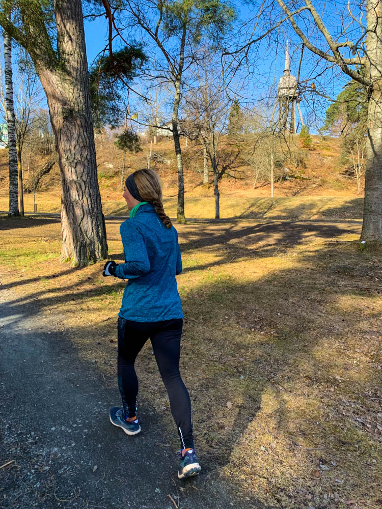 Melanie beim Joggen in Jöngköping in Schweden. Der Himmel ist strahlend blau und Melanie joggt in einem Park.