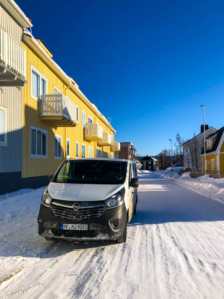Van Vivaldi steht in Kiruna auf schneebedeckter Fahrbahn. Der Himmel ist strahlend blau.