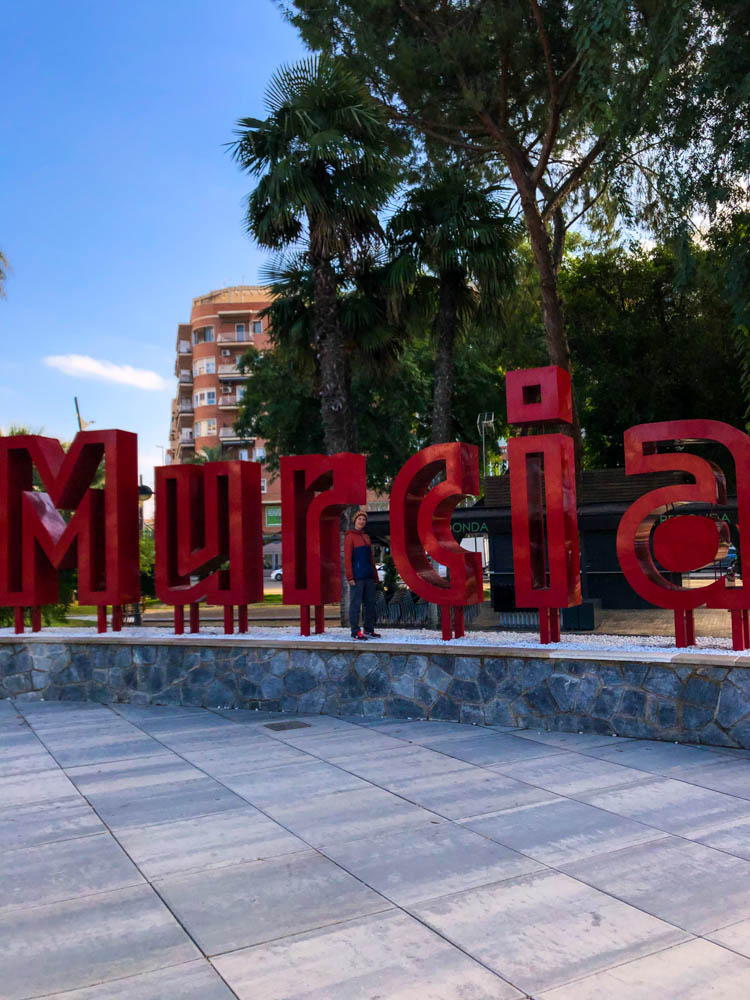 In einem kleinen Parkstück mitten in der Stadt sind große Buchstaben aufgestellt, welche Murcia schreiben. Melanie posiert zwischen diesen roten Buchstaben. Rückfahrt über Spanien - Murcia