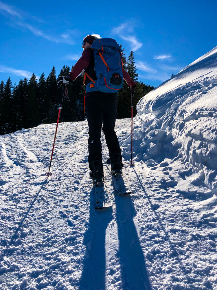 Julian im Aufstieg mit dem Splitboard auf dem Weg zur Alpspitze bei Nesselwang. Der Himmel ist kräftig blau, der Schnee leuchtet hell von der darauf scheinenden Sonne.