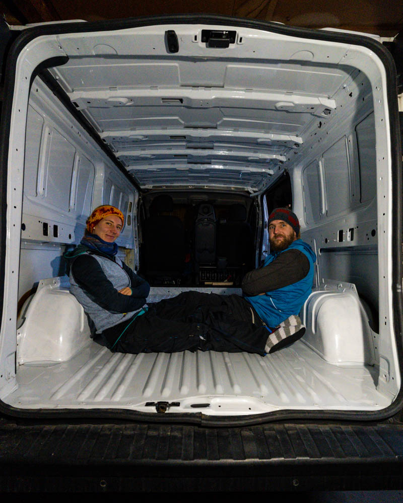 Melanie und Julian sitzen in ihrem leeren Van. Sie sitzen sich gegenüber und schauen in die Kamera. 730 Tage auf Weltreise
