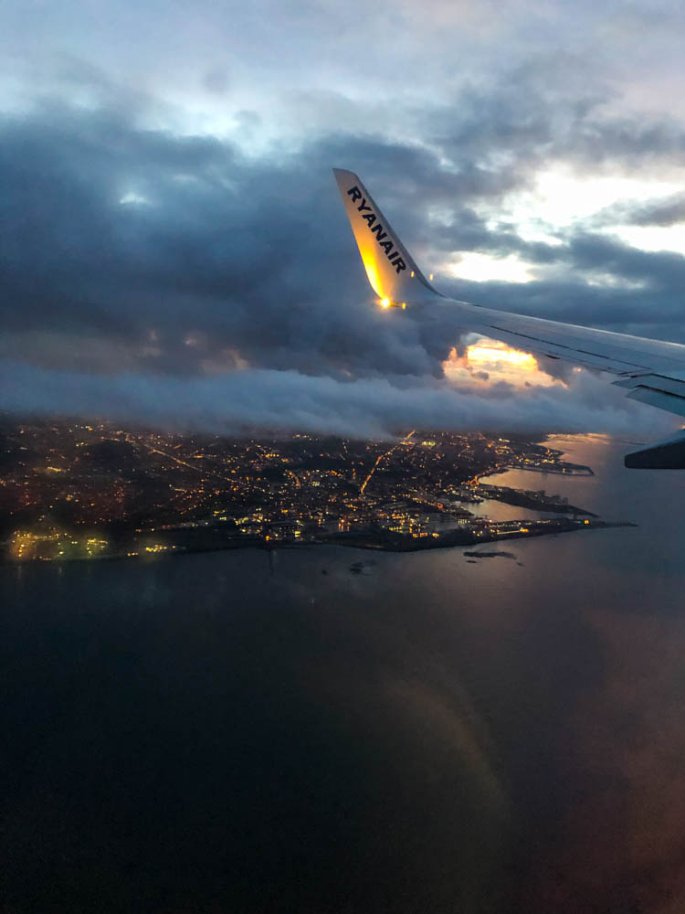 Foto aus dem Fenster von Flugzeug. Edinburgh am Abend beleuchtet.