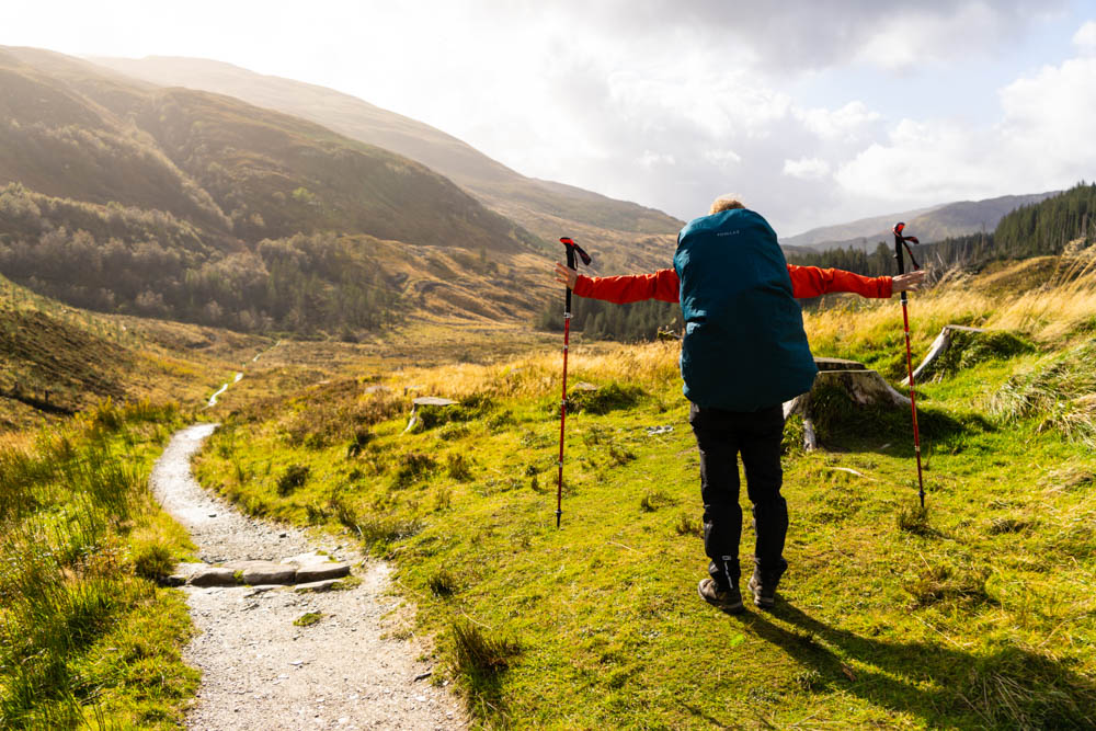Melanie streckt ihre Arme in die Höhe und blickt auf die schottischen Highlands. Trekking West Highland Way